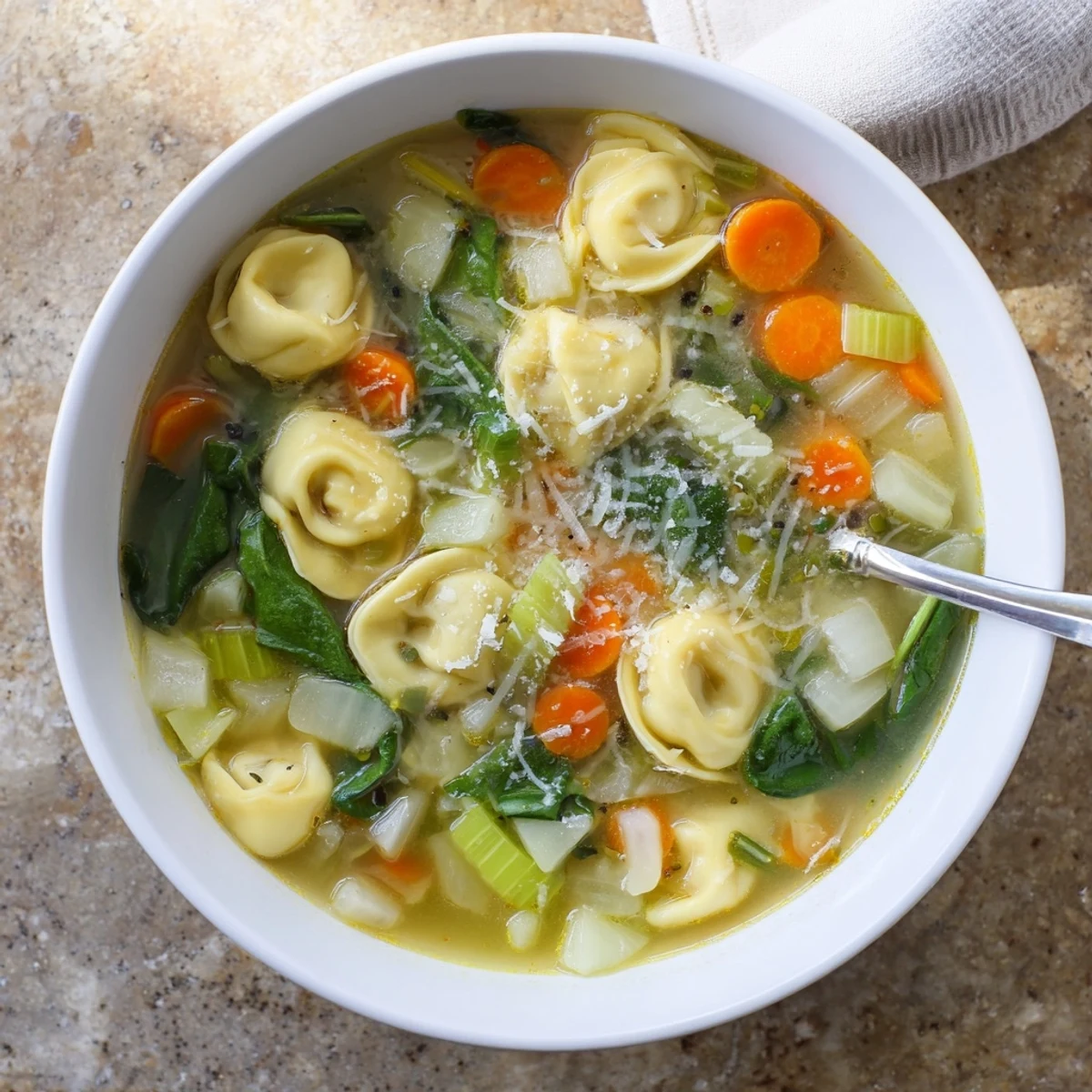 Creamy Instant Pot tortellini soup with tender vegetables and melted parmesan cheese in a rich broth