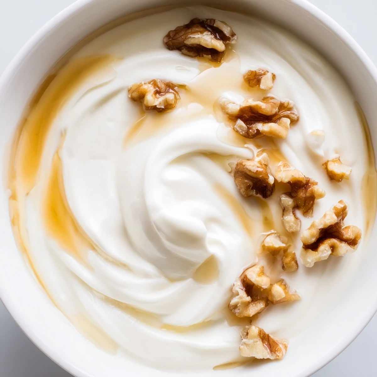 Creamy homemade Greek yogurt topped with fresh berries and honey in a white bowl