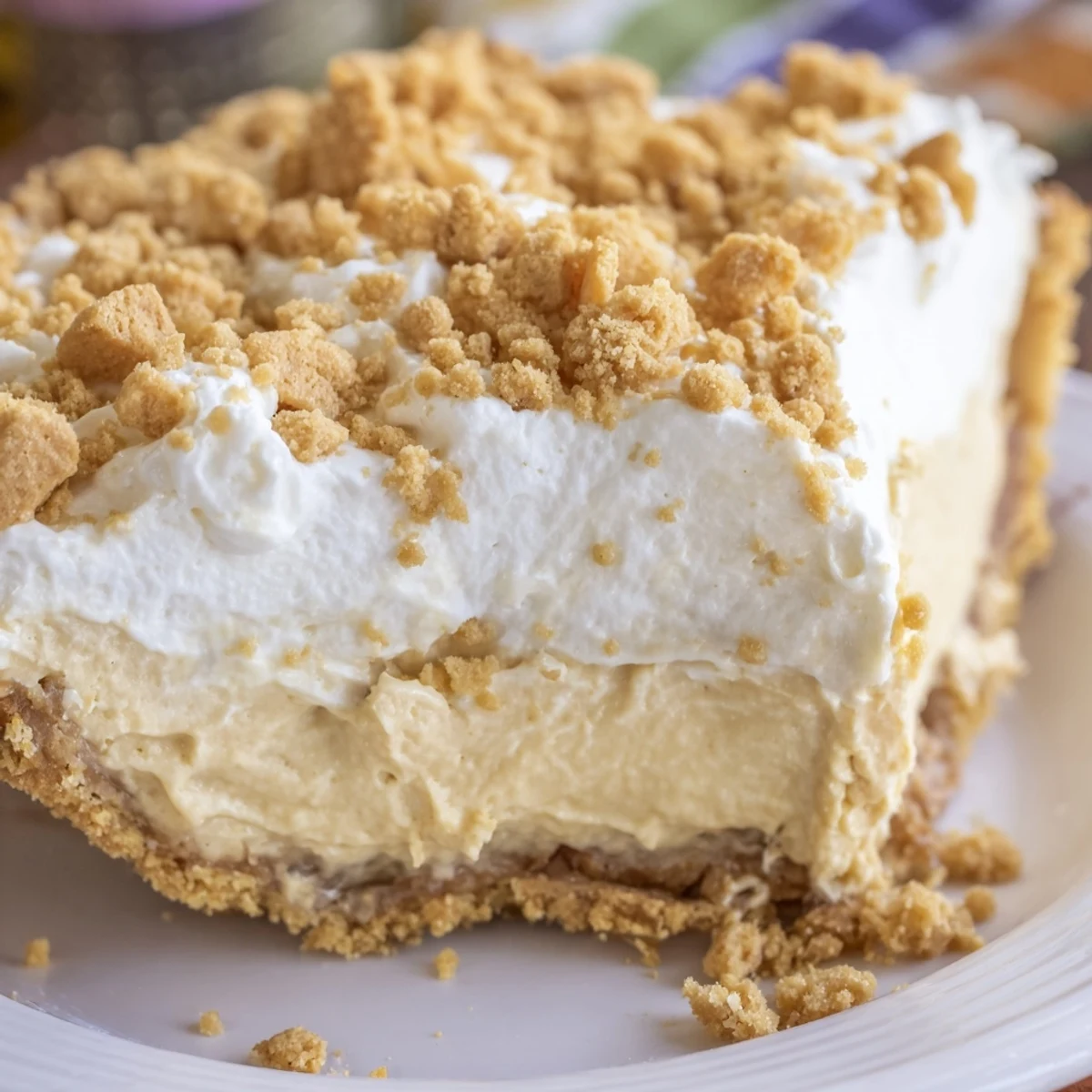 Creamy Amish Peanut Butter Dream Pie topped with fluffy whipped cream and golden crumbs