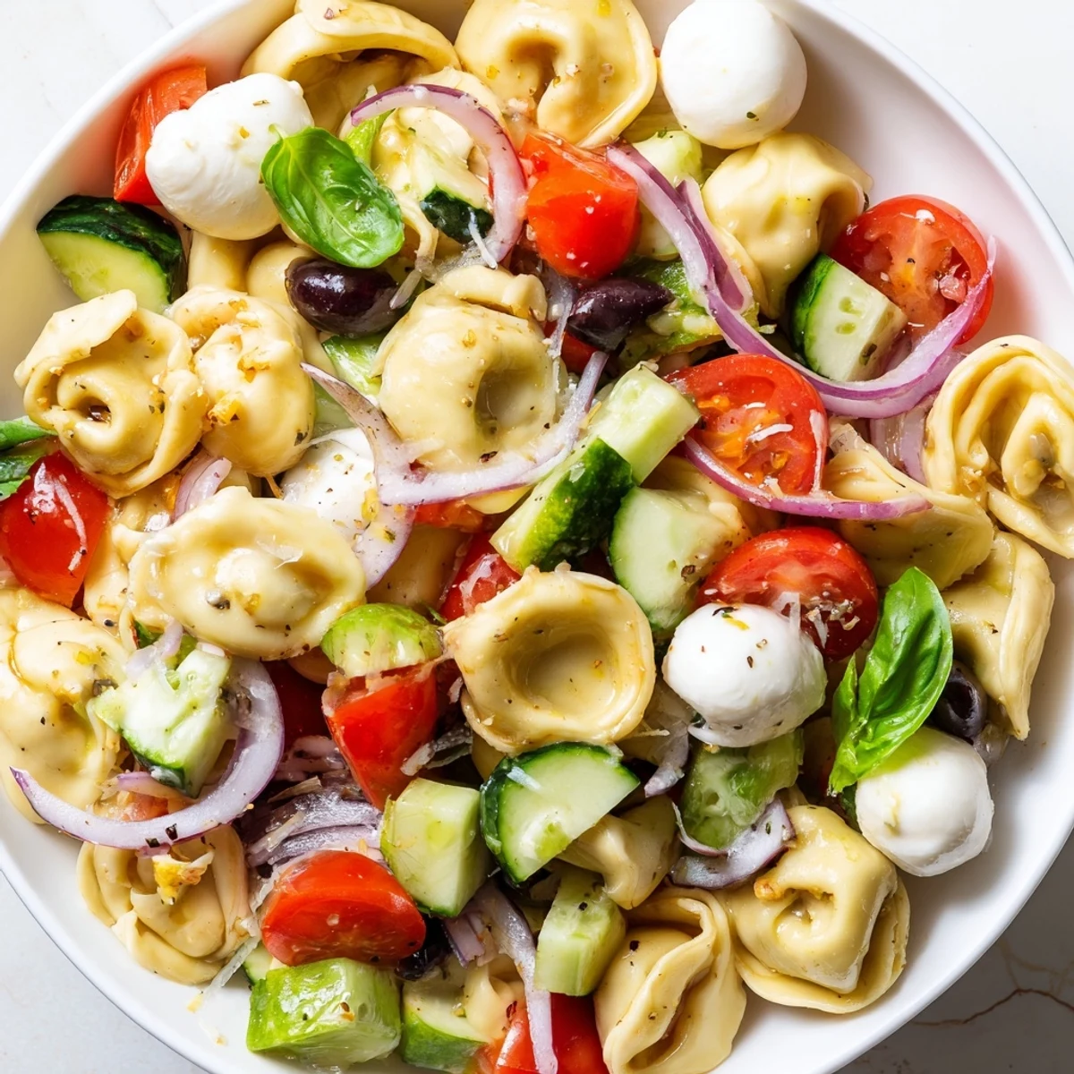 Colorful tortellini salad with crisp vegetables and zesty Italian dressing in a serving bowl