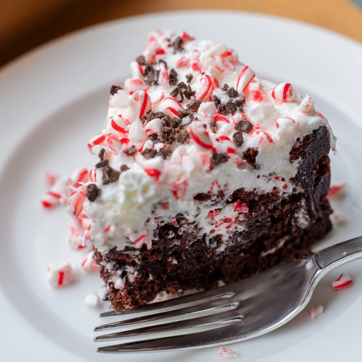 Peppermint Poke Cake chilled, fluffy whipped topping, bright crushed peppermint garnish.