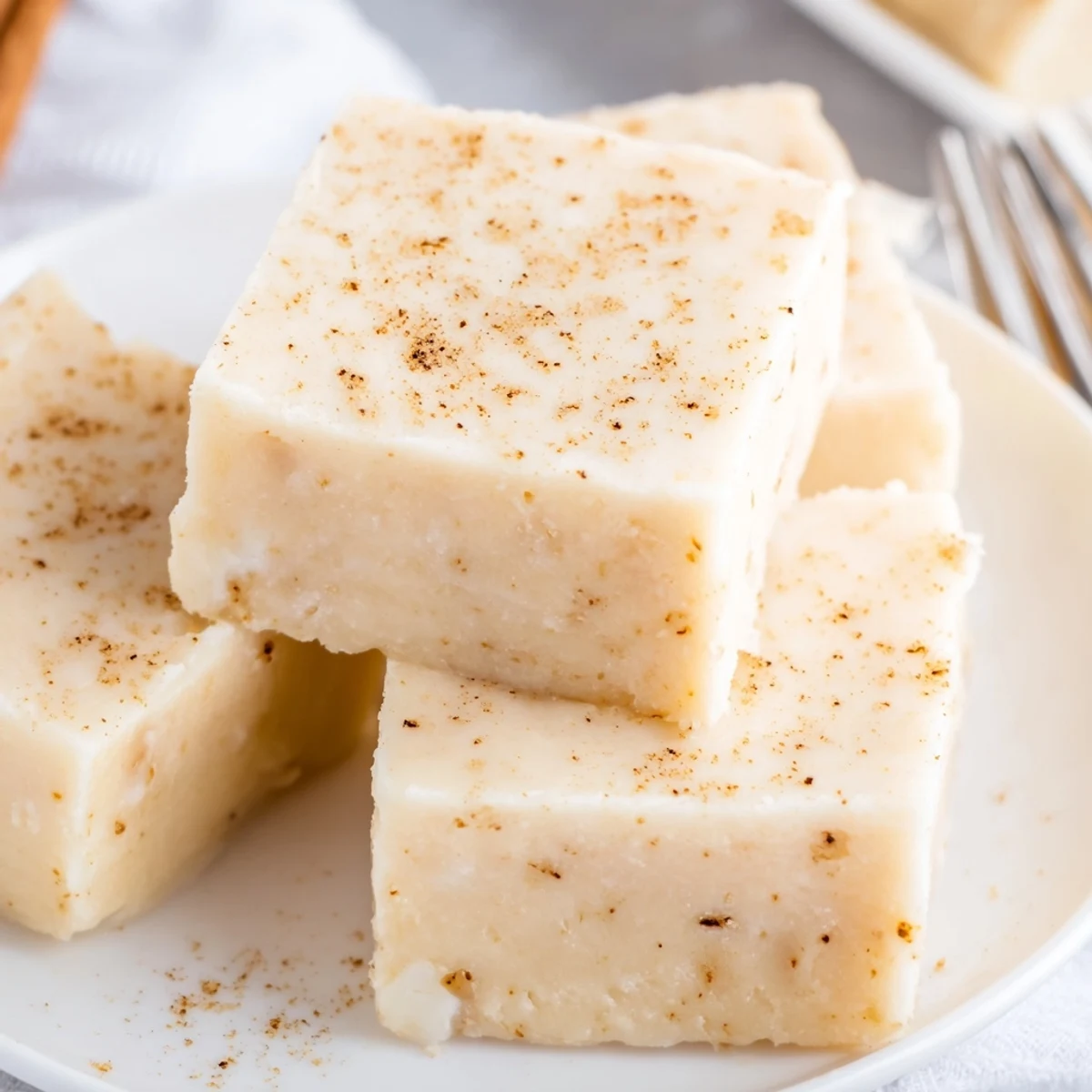 Silky white Eggnog Fudge cooling in pan, ready to cut into squares