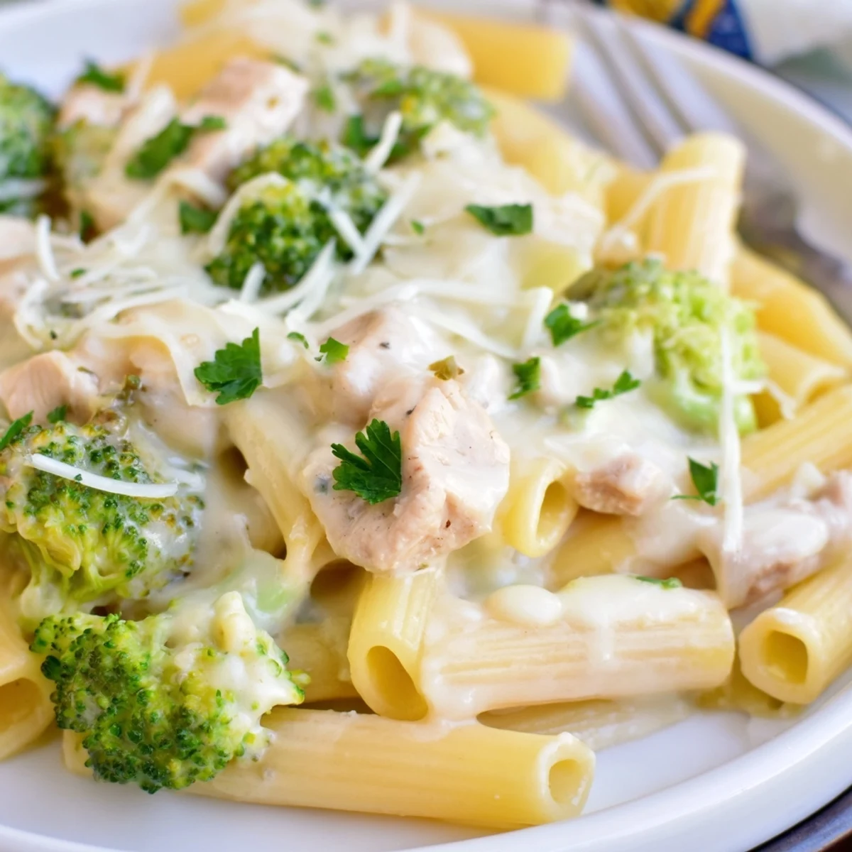 Sliced Chicken Broccoli Alfredo Bake on plate with garlic bread, parsley