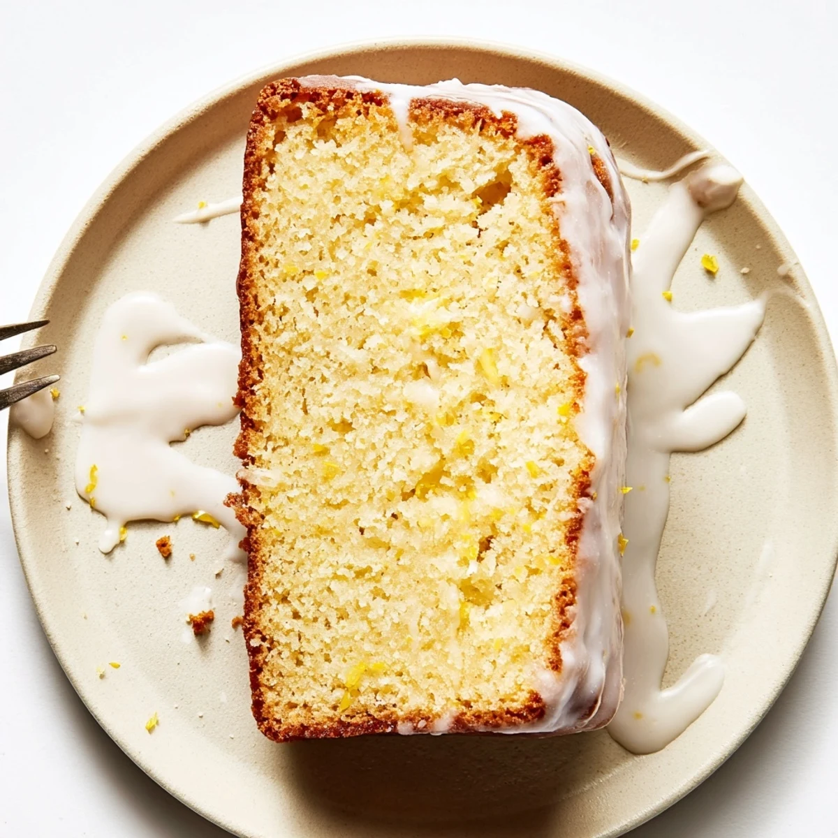 Moist lemon loaf cake sliced to reveal tender crumb topped with tangy glaze