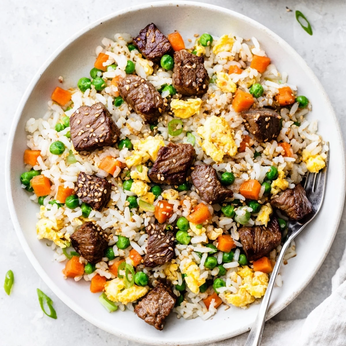 Golden Blackstone hibachi steak fried rice loaded with tender beef, colorful vegetables, and savory seasonings