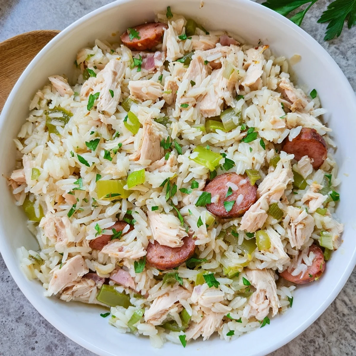 Spoonful of savory Southern Chicken Bog showcasing moist chicken, smoky sausage, and seasoned rice garnished with fresh parsley