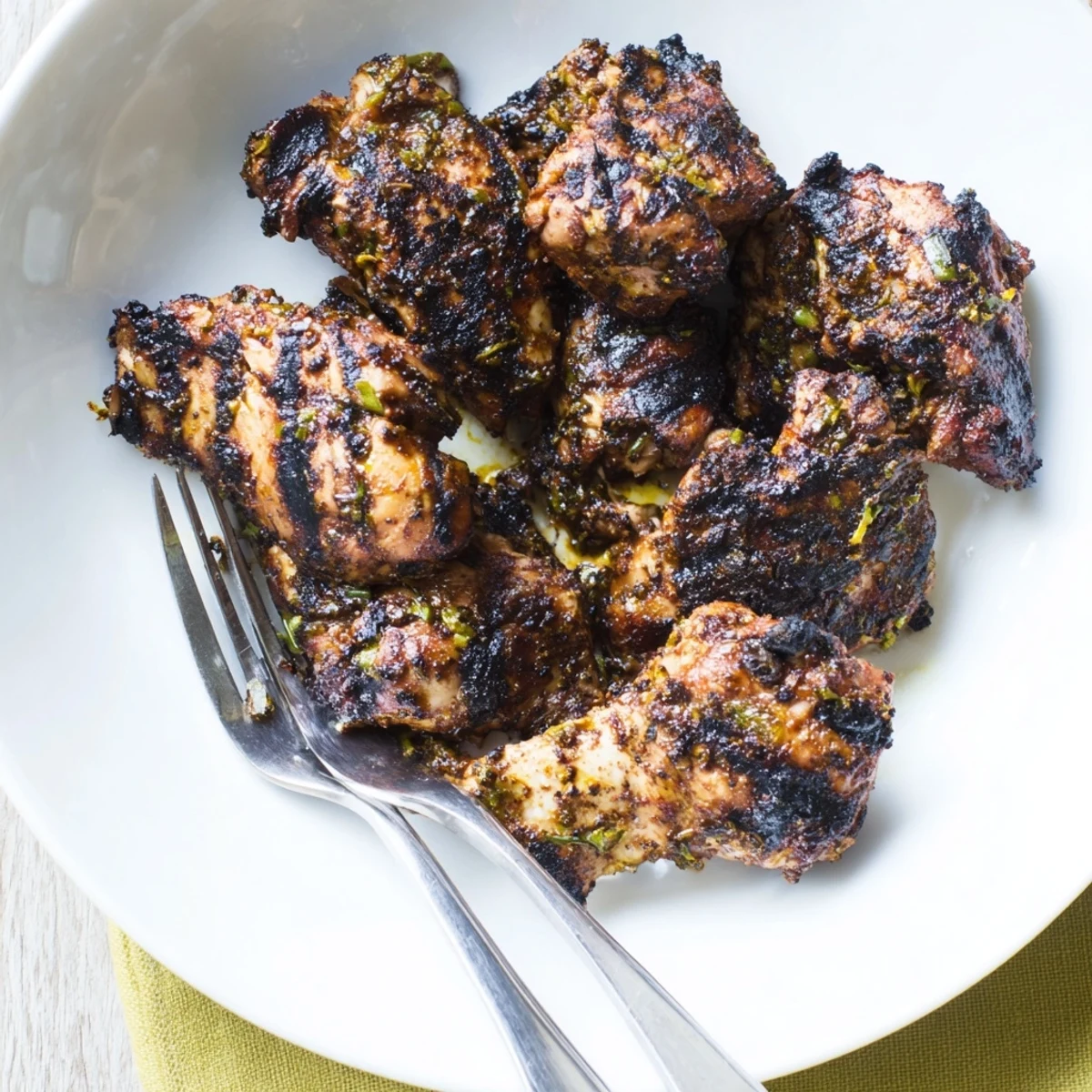 Tender Jamaican Jerk Chicken resting on a platter with vibrant jerk seasoning and grill marks
