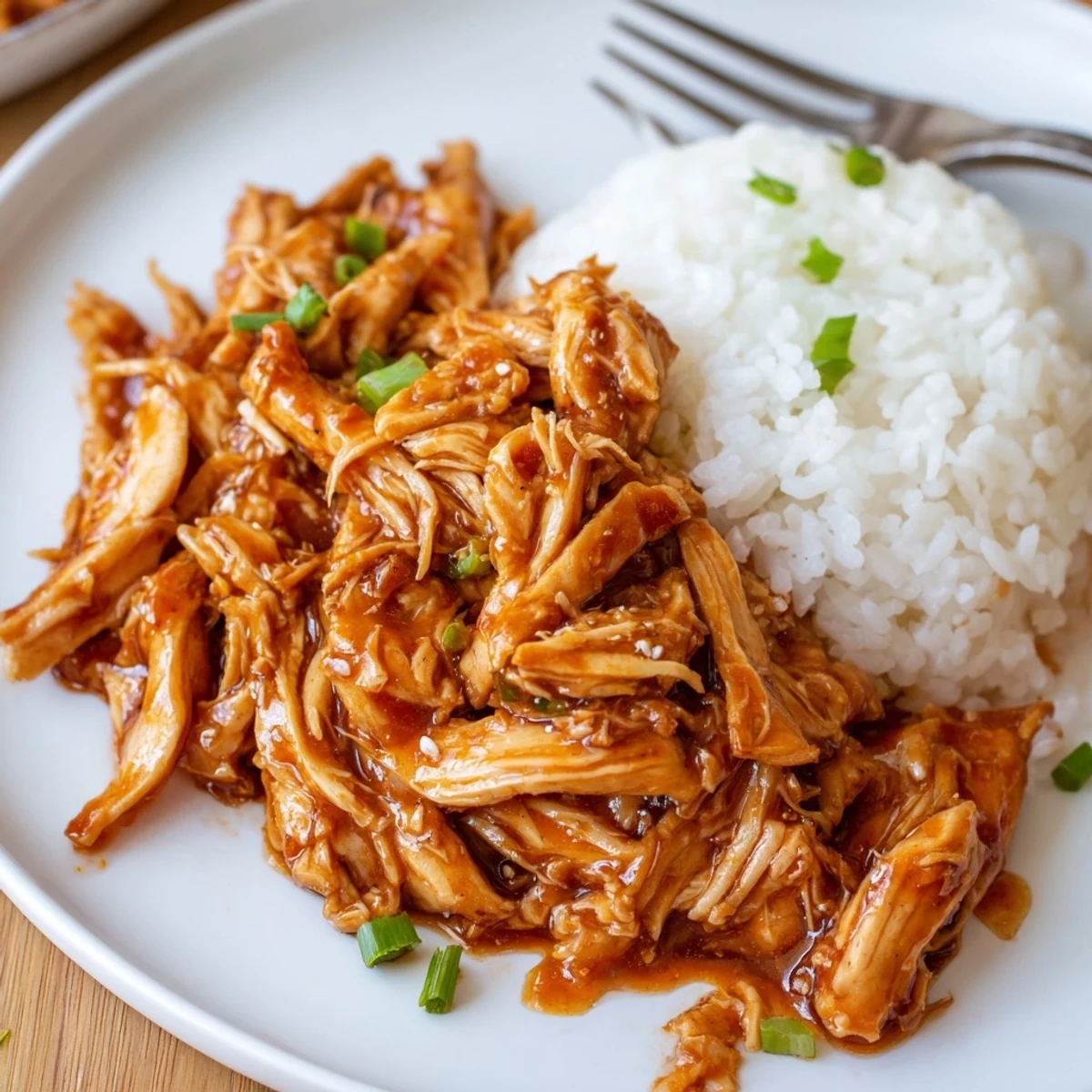 Slow-cooked Crockpot Honey Garlic Chicken, tender shreds in sticky sweet-savory glaze