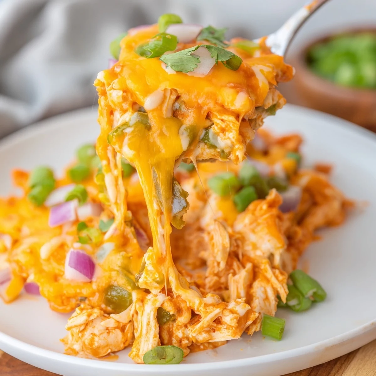 Creamy jalapeno buffalo chicken casserole topped with green onions and melted mozzarella