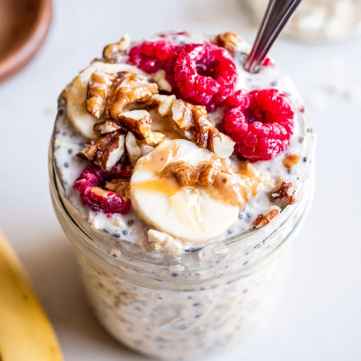 Thick and creamy protein overnight oats topped with fresh berries in a glass jar